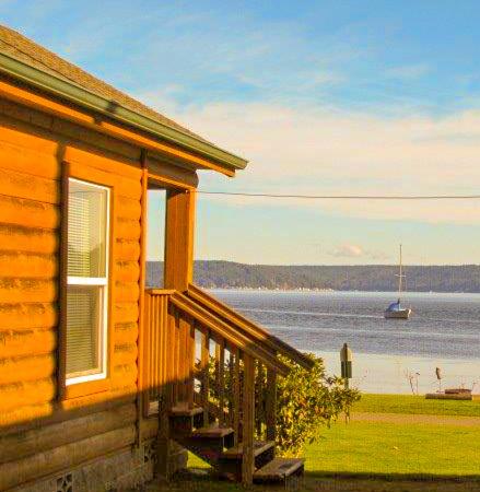 a cabin with a view of the water and a boat at The Waterfront at Potlatch in Shelton