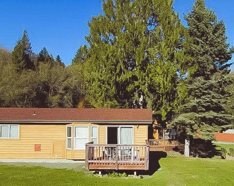 a small house with a large deck in a yard at The Waterfront at Potlatch in Shelton