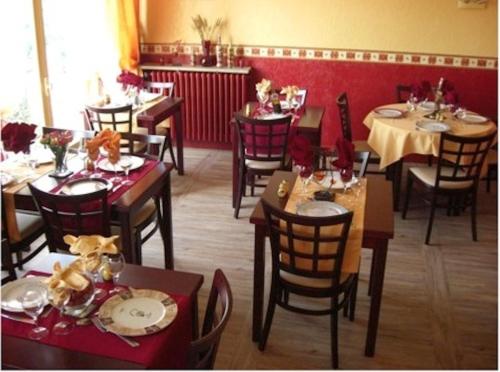 een eetkamer met tafels en stoelen en een eettafel bij Hôtel Restaurant Les oliviers in Nyons