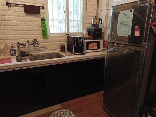 eine Küche mit einem schwarzen Kühlschrank und einer Spüle in der Unterkunft Backpack Home 497-No.2 in Jincheng