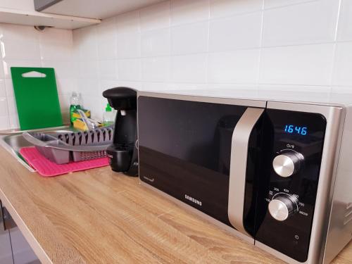 a microwave on a counter in a kitchen at SW Cosy Apart - Chambly Persan Roissy in Persan