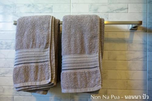 zwei Handtücher hängen auf einem Handtuchhalter im Bad in der Unterkunft NON NA PUA - นอนนา ปัว in Pua