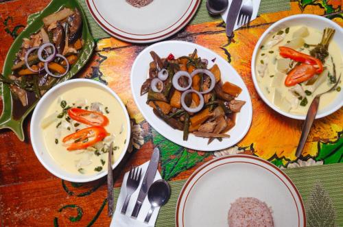 a table with plates of food on a table at Natura Vista in Panglao