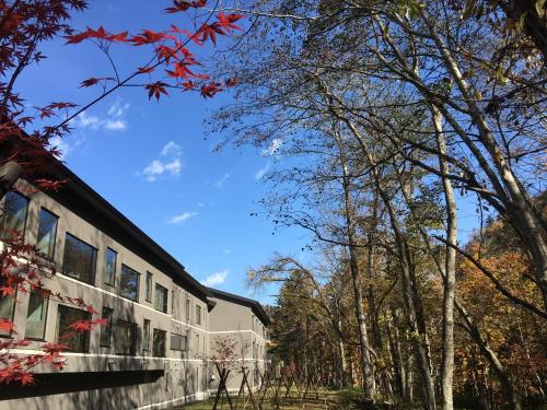 a building with trees in front of it at Okujozankei Onsen Kasho Gyoen in Jozankei