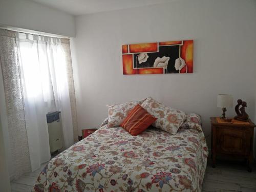 1 dormitorio con 1 cama y una pintura en la pared en Hermoso departamento en zona residencial y polo cervecero en Mar del Plata