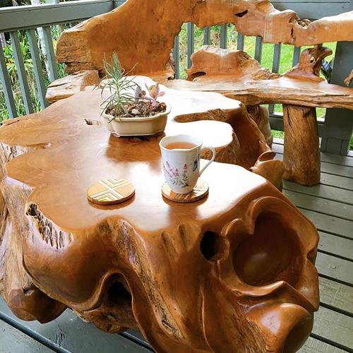 a table made out of a tree stump with a cup of coffee at The Inn at Kulaniapia Falls in Hilo