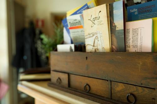 a wooden drawer filled with books on a table at Hotel Giardino in Pieve di Cadore