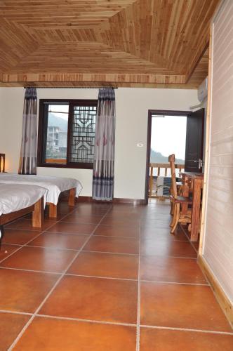 a room with two beds and a wooden ceiling at Longji Holiday Hotel in Longsheng