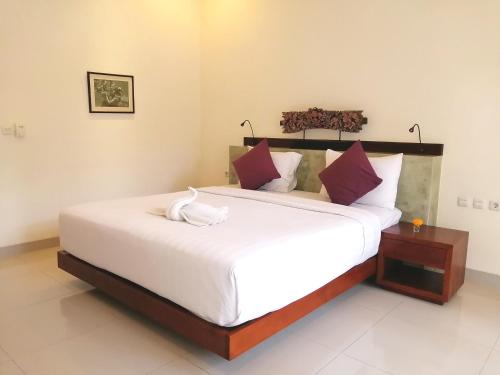 a bedroom with a large bed with white sheets at Ubud Bungalow in Ubud