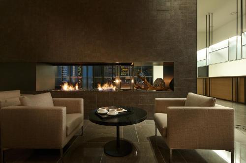 a living room with two chairs and a fireplace at Shilla Stay Dongtan - Samsung Digital City in Hwaseong