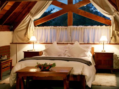 a bedroom with a large bed with a window at Hostería Canela B&B in Esquel