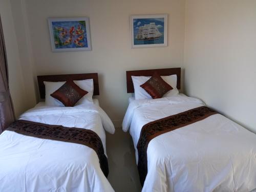 2 Betten in einem Zimmer mit weißer Bettwäsche in der Unterkunft Supunnika Garden Guesthouse in Fang