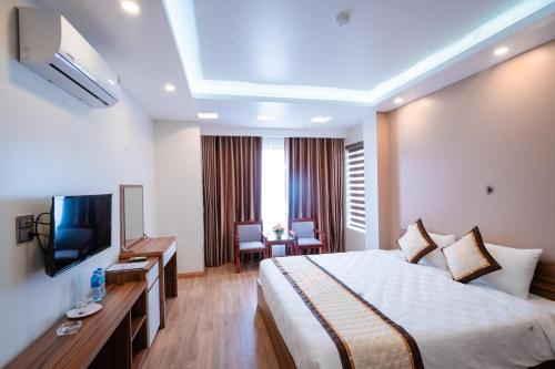 a hotel room with a bed and a television at Sky hotel 390 QUang Trung Thành phố Uông Bí tỉnh Quảng Ninh in Uông Bí