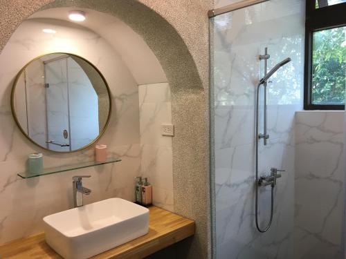 a bathroom with a sink and a shower with a mirror at Greenville Maioli in Tongxiao