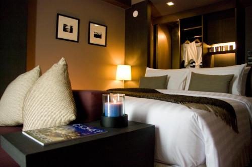 a hotel room with a bed and a candle on a table at AYA Boutique Hotel Pattaya - SHA Plus in Pattaya
