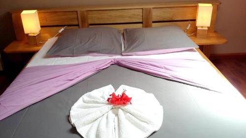 a large bed with a red flower on it at Appartement de 3 chambres avec jardin clos et wifi a Le Tampon in Le Tampon