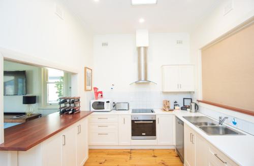 a kitchen with white cabinets and a sink at Longview Vineyard in Macclesfield