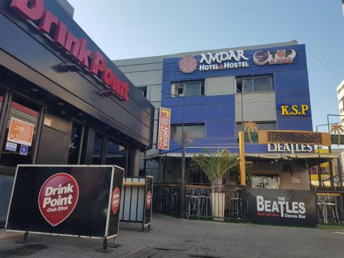 a street corner with a restaurant and a building at Amdar Hostel in Eilat