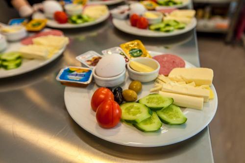 eine Platte mit Käse und Gemüse auf dem Tisch in der Unterkunft Business Palas Otel in Kocaeli