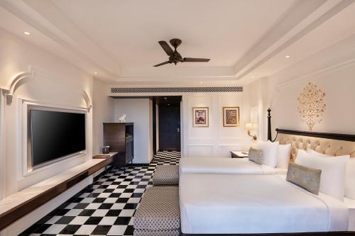 a hotel room with two beds and a flat screen tv at Aurika, Udaipur - Luxury by Lemon Tree Hotels in Udaipur
