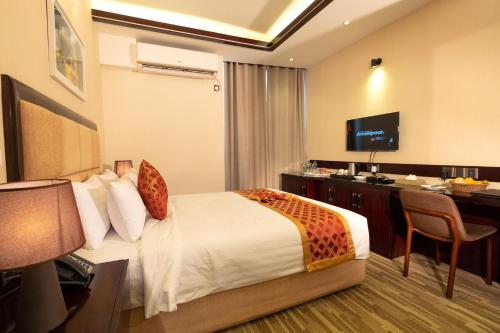 a hotel room with a bed and a desk at After Hours Residence in Dhaka