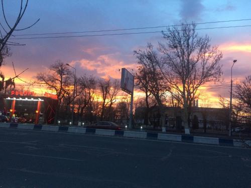 a sunset over a street with trees and a building at HOTEL N1 in Yerevan