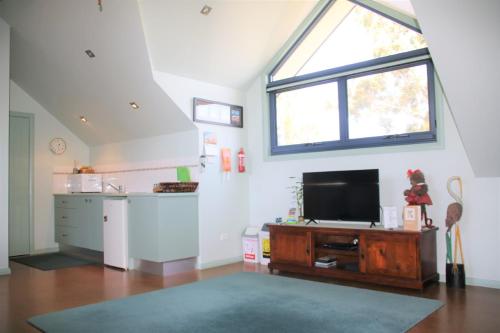 a living room with a flat screen tv and a window at Salamander Bay Bed and Breakfast in Salamander Bay