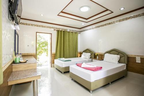 - une chambre avec 2 lits et une télévision dans l'établissement Bualuang Boutique Resort, à Ang Thong