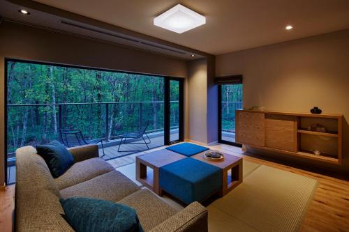 a living room with a couch and a table at Okujozankei Onsen Kasho Gyoen in Jozankei