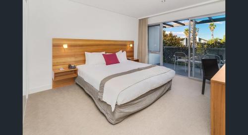 - une chambre avec un grand lit et un balcon dans l'établissement Magenta Shores 3 Bedroom Villa, à Magenta