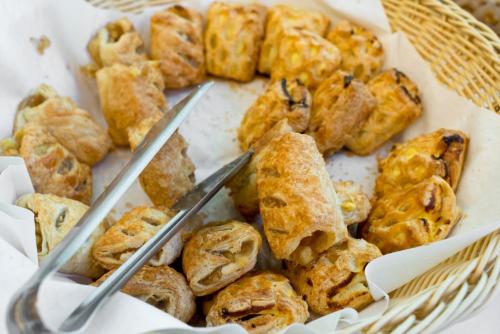 a basket of pastries with two silver tongs in it at BEST BALTIC Hotel Druskininkai Central in Druskininkai