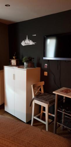 Il comprend une cuisine équipée d'un réfrigérateur blanc et d'une table avec une chaise. dans l'établissement Location court terme, à Namur