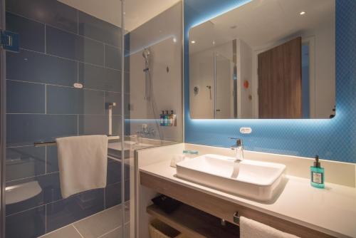 a bathroom with a sink and a mirror at Holiday Inn Express Shanghai Huijin, an IHG Hotel in Shanghai