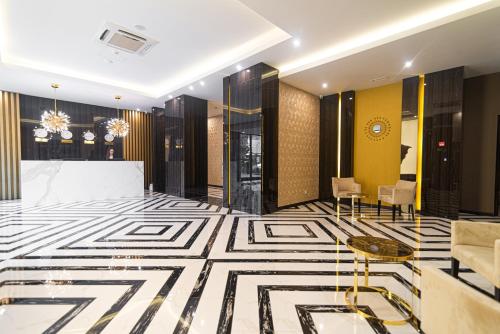 a lobby with a black and white patterned floor at Resident City Hotel in Almaty