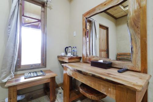 ein Badezimmer mit einem hölzernen Waschtisch und einem Spiegel in der Unterkunft Alloyna Country Cottage Brastagi in Berastagi