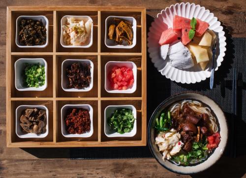 a tray of food with bowls of food and a plate of food at Yakamoz Erhai Hotel in Dali