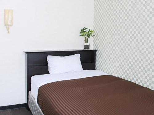 東京的住宿－HOTEL LiVEMAX BUDGET Higashi Ueno，一张床上,上面有黑色床头板