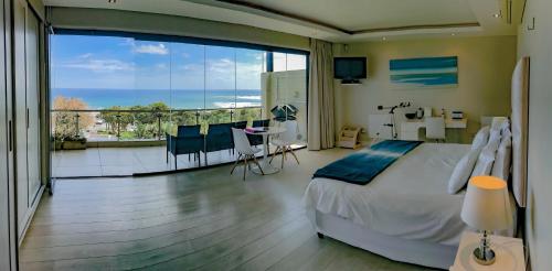 1 dormitorio con 1 cama y balcón con vistas. en Sea Mount, en Ciudad del Cabo