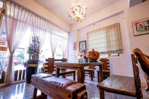 a dining room with a table and chairs and a chandelier at Happiness Hanada B&B in Hualien City