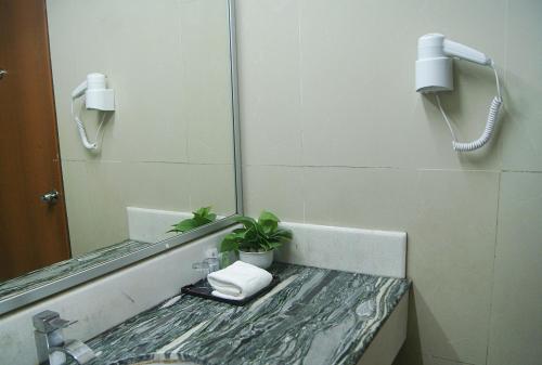 a bathroom with a sink and a mirror at Tang Dynasty Park Hotel in Kota Kinabalu