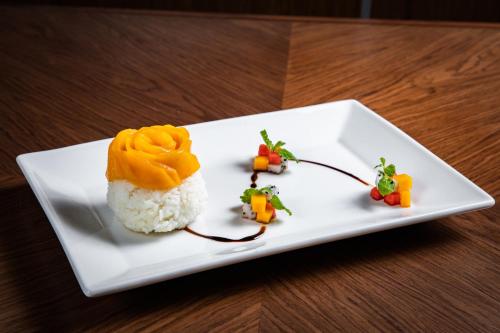 a white plate with some food on a table at Oakwood Residence Hanoi in Hanoi