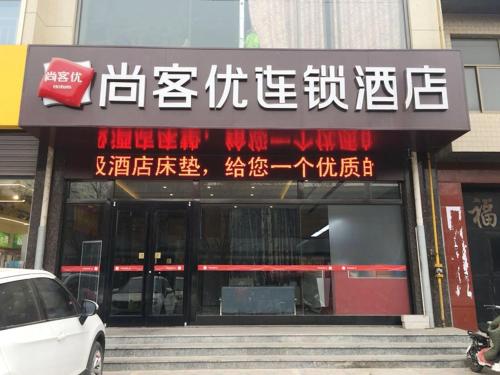 un bâtiment avec un panneau à l'avant dans l'établissement Thank Inn Plus Hotel Hebei Shijiazhuang Wuji County Bus Station, à Shijiazhuang