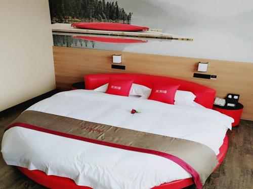 a bedroom with a large bed with red pillows at Thank Inn Plus Hotel Shandong Binzhou Huimin County Huji Driving Test Center in Binzhou