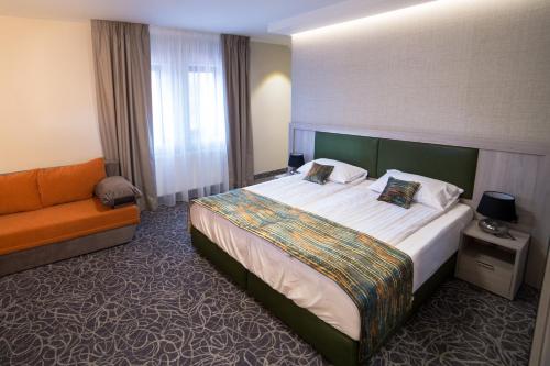une chambre d'hôtel avec un lit et un canapé dans l'établissement Pensiunea Luceafărul Sibiu, à Sibiu