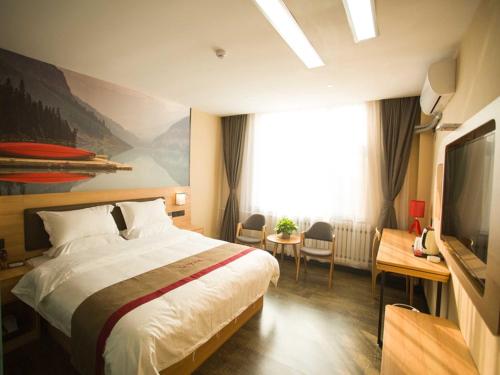 um quarto de hotel com uma cama e uma televisão em Thank Inn Plus Hotel Shandong Zibo Zhangdian District Jinjing Avenue Wanxianghui em Zibo