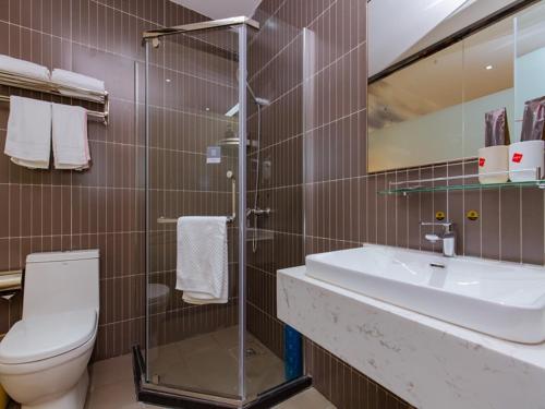 La salle de bains est pourvue de toilettes et d'un lavabo. dans l'établissement Thank Inn Plus Hotel Sichuan Chengdu Jianyang Dongcheng Huafu, à Chengdu