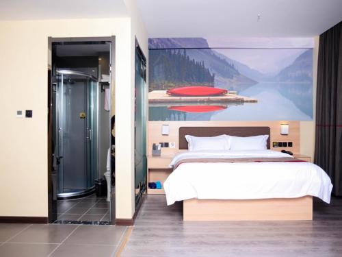 1 dormitorio con 1 cama con una pintura en la pared en Thank Inn Plus Hotel Hebei Cangzhou Botou Development Zone Sanjing Road, en Cangzhou