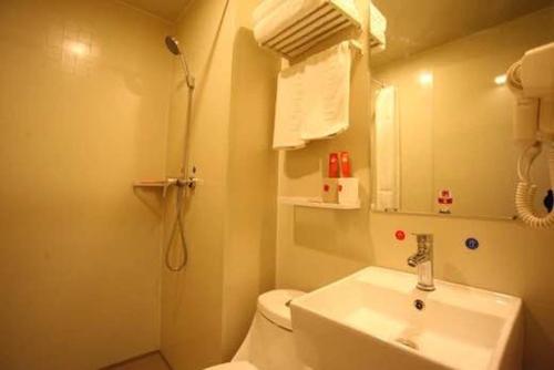 a bathroom with a sink and a toilet and a shower at Thank Inn Plus Hotel Shandong Rizhao Donggang District Lighthouse Plaza in Rizhao