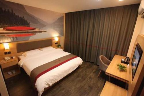 a hotel room with a large bed and a desk at Thank Inn Plus Hotel Shandong Rizhao Donggang District Lighthouse Plaza in Rizhao
