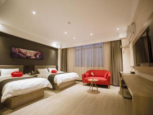 um quarto de hotel com duas camas e uma cadeira vermelha em Thank Inn Plus Hotel Guangxi Baise Tianyang County em Baise